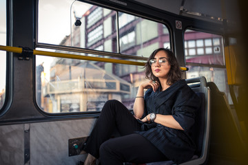 Woman sitting in a bus of Prague full of multiculturalism