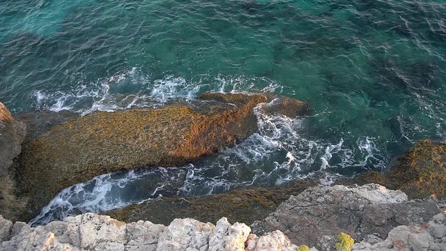 Top view of sea waves hitting rocks on the beach in Cyprus