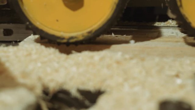 Spinning spiked wheels of board refiner machine working on wood at lumber factory, close up