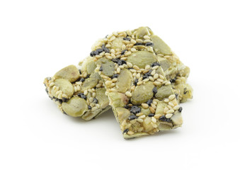 Pumpkin kernels with sesame bar on white background
