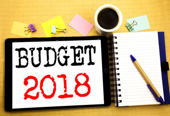 Budget 2018. Business concept for Household budgeting accounting planning Written on tablet laptop, wooden background with sticky note, coffee and pen