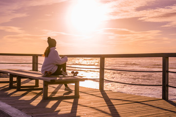 Girl with skateboard watching the ocean