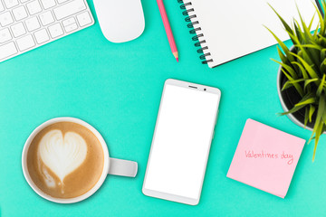 top view of smartphone with coffee cup and computer on office desk,Valentine's Day Concept