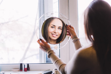 young beautiful girl smiling looking in the mirror