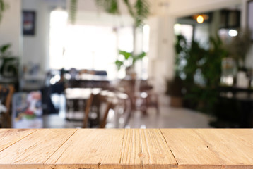 Empty wooden table in front of abstract blurred background of coffee shop . can be used for display or montage your products.Mock up for display of product.