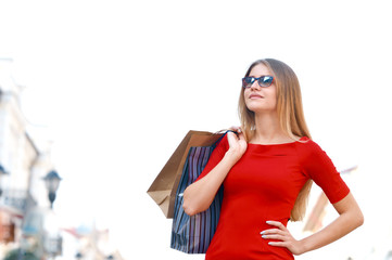 Portrait young charming long-haired woman holding shopping bags