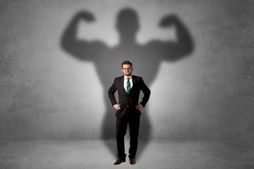 Businessman with muscular shade behind his back