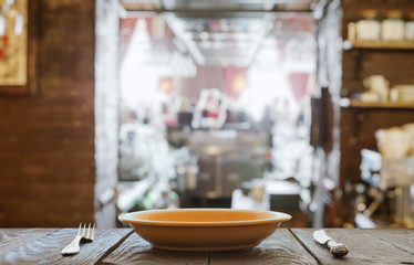 empty plate with fork and knife on wooden table
