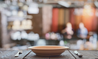 empty plate with fork and knife on wooden table