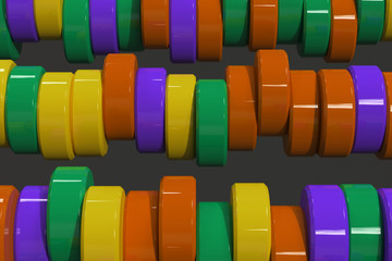 Pattern of yellow, violet and green cylinder tablets on black background