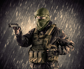 Armed terrorist man with mask on rainy background