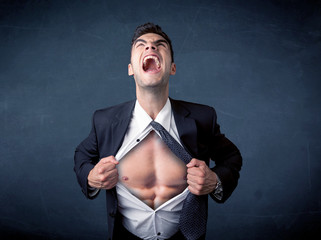 Businessman tearing off shirt and showing mucular body