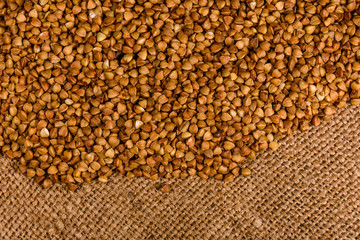Pile of the raw buckwheat on sackcloth. Top view