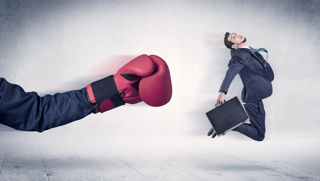 Huge Boxing Gloves punches businessman concept