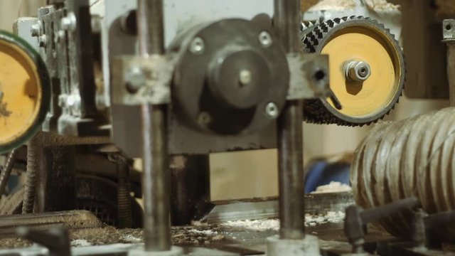Rolling spiked wheels of block refiner machine working on wood at sawmill production, close up