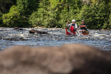 Fototapeta premium Group of people paddling the whitewater of the Noire River in Quebec, Canada.