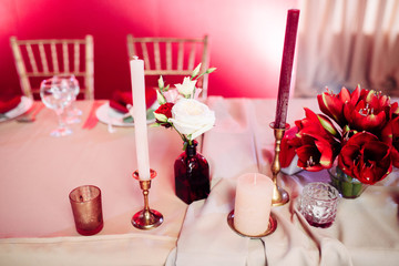Decorated area in gold and burgundy colors with white candles and flowers