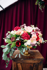 Luxurious bouquet with white and purple flowers in a vase on a wooden stand