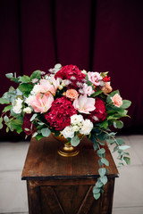 Luxurious bouquet with white and purple flowers in a vase on a wooden stand