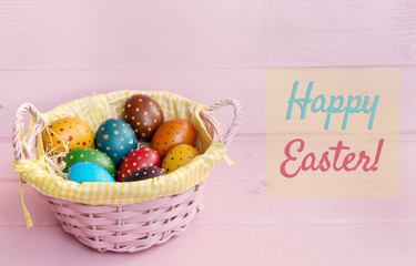 Easter Background with Eggs  in Basket and Happy Easter Text on a Pink Planks Background 