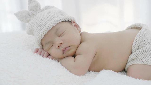 4K Close up of Asian baby laying on a soft blanket, Slow motion shot