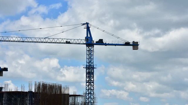 A short video clip using a crane to build a building. In the bright sky