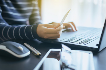 Naklejka premium Close up of hand woman holding credit card and using laptop for online shopping concept