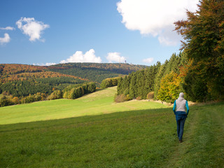 Wanderer im Herbst im Mittelgebirge mit Inselberg