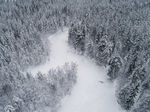 High Angle Aerial View Of Frozen River Bend And Boreal Forest Covered By Snow