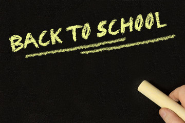 Ein Mann schreibt auf einer Kreidetafel Back to School