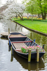 Boat with tulips on water canal in Keukenhof garden park from Netherlands (Holland).