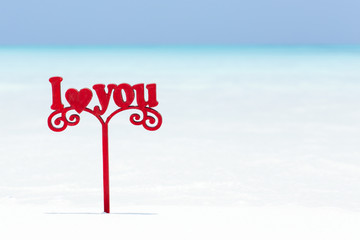 I LOVE YOU message decorated on white sandy beach