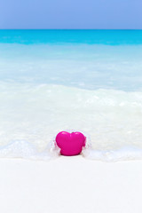 Valentines day concept greeting card, red heart on pristine sandy beach