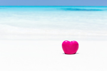 Fototapeta premium Valentines day concept greeting card, red heart on pristine sandy beach