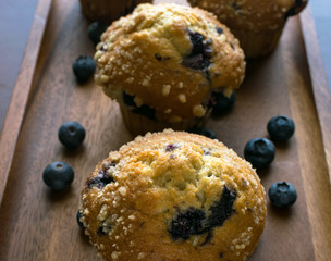 Blueberries with muffins on wooden tray