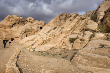 Tourists walking in Petra gorge at cold winter day