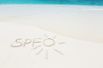 Written word SPF and drawing sun an sandy beach