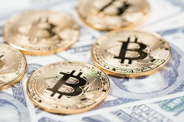 Bitcoins on dollar banknotes background