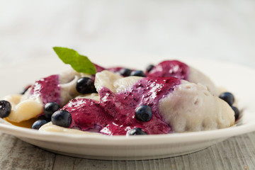 Delicious dumplings with fresh blueberries served with whipped cream and sugar or sauce.