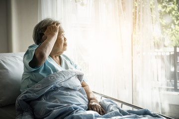 Elderly patients sitting in bed waiting for relatives to visit with loneliness.