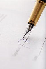 Close-up of gilded fountain pen signing contract, document. Vertical image.