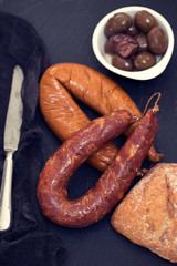 smoked sausages with bread on black ceramic board