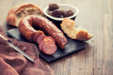 smoked sausages with bread on black ceramic board