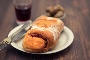 bread with smoked sausage on plate and red wine