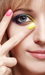 Closeup  image of human female eye with violet shadows, blue and and yellow makeup