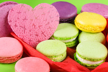 Fototapeta na wymiar large pink heart surrounded by colorful macaron