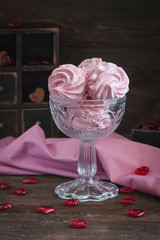 Homemade marshmallow or zephyr with a cup of tea over the wooden background.