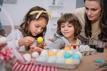 happy kids painting easter eggs mother at home with mother