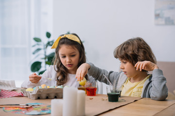 adorable kids painting easter eggs together for holiday