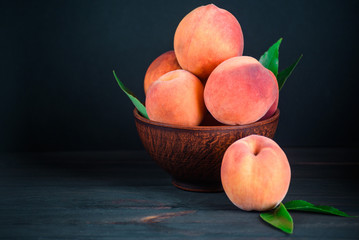 Ripe aromatic peach with leaves on a wooden table